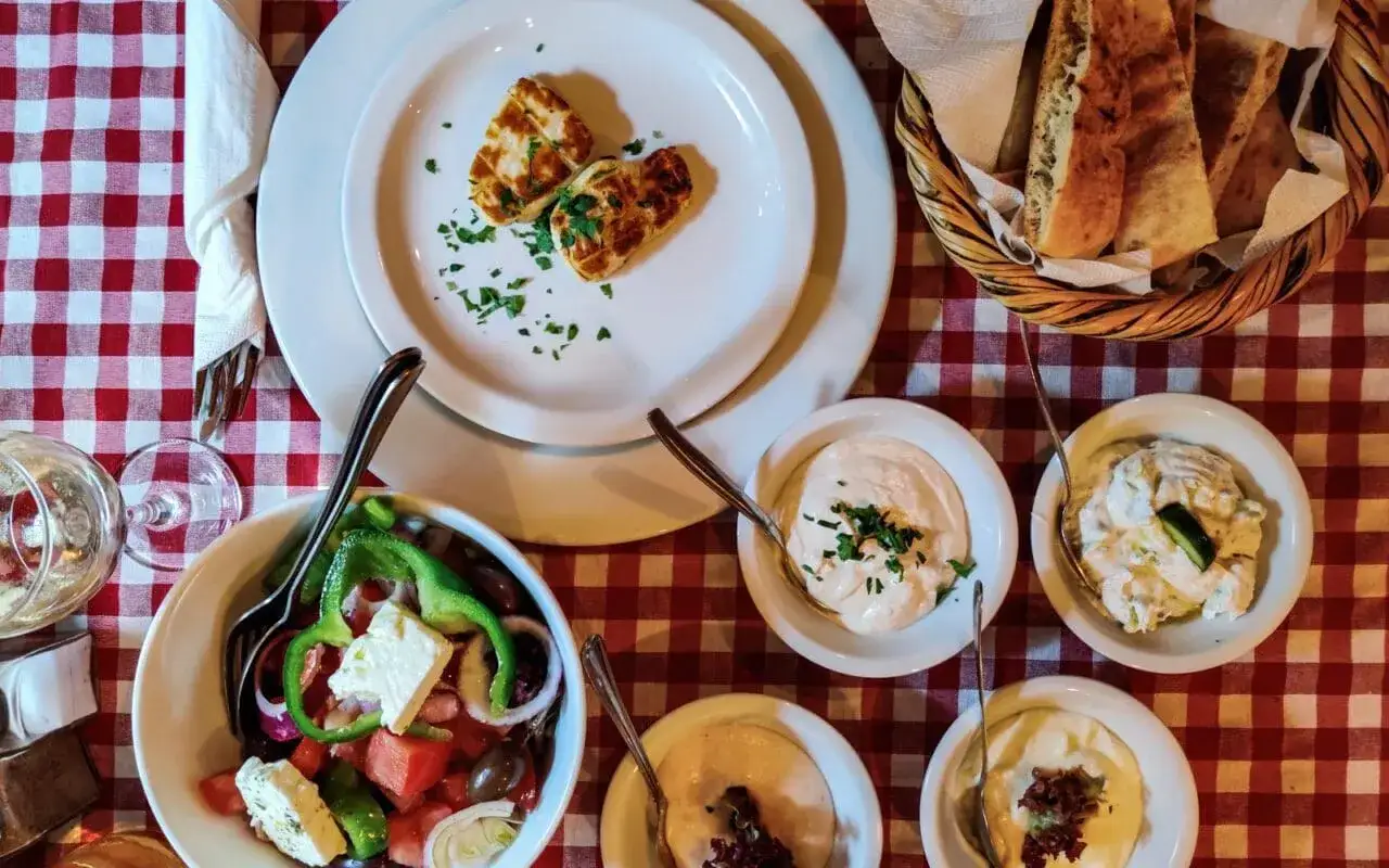 Pyszne jedzenie z Cypru: sałatka grecka, halloumi, pieczywo i dipy. Idealny posiłek na wakacjach.
