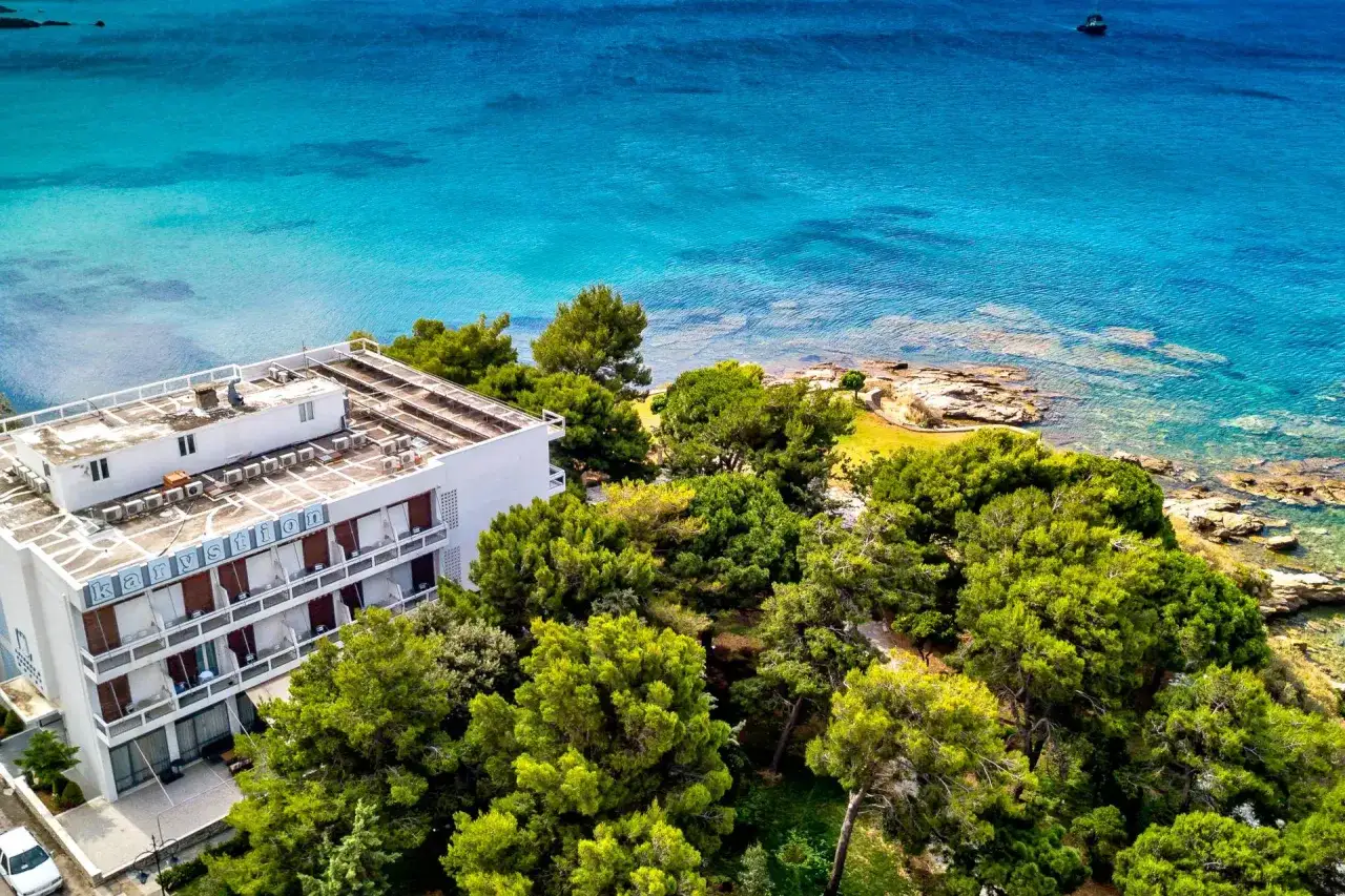 Hotel Karystion na wyspie Evia, otoczony zielenią, z widokiem na turkusowe morze.