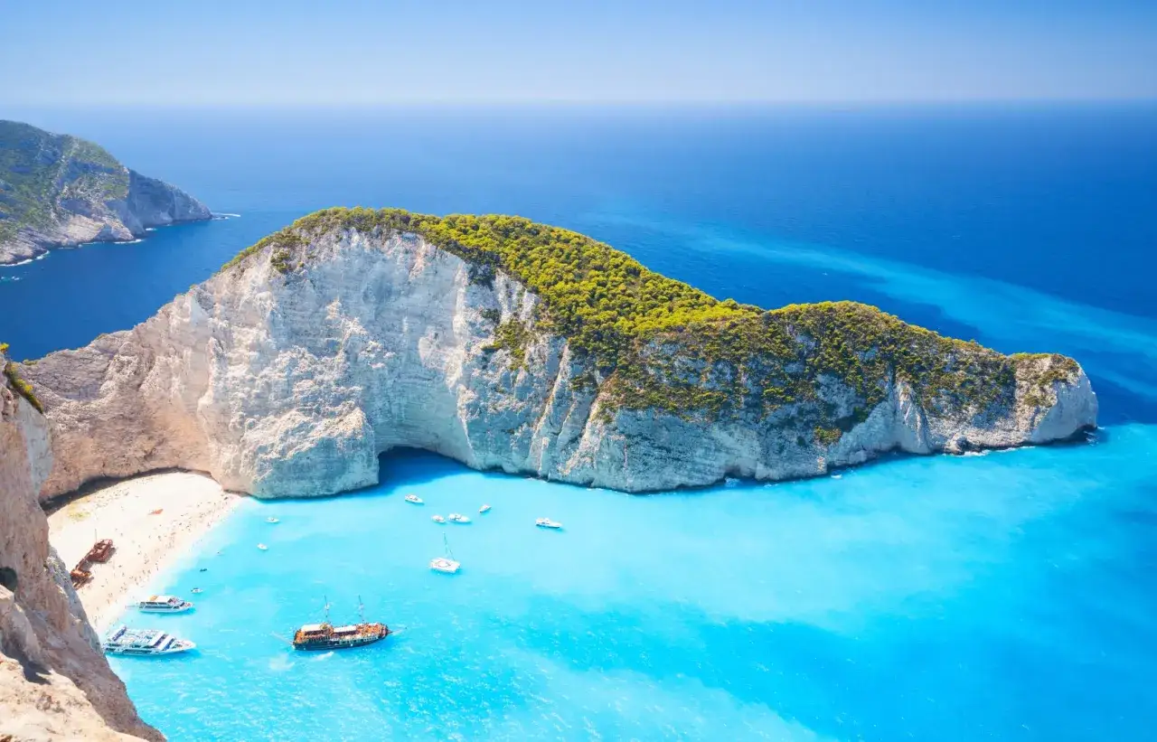 Widok na Navagio, słynną plażę na Zakynthos, jedną z najpiękniejszych wysp w Europie. Turkusowa woda, białe klify i łodzie tworzą rajski krajobraz.